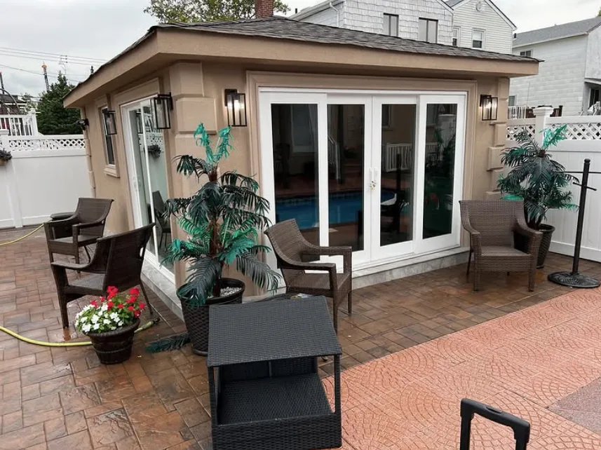 Pool house with ceramic film on its sliding glass doors, patio furniture in front