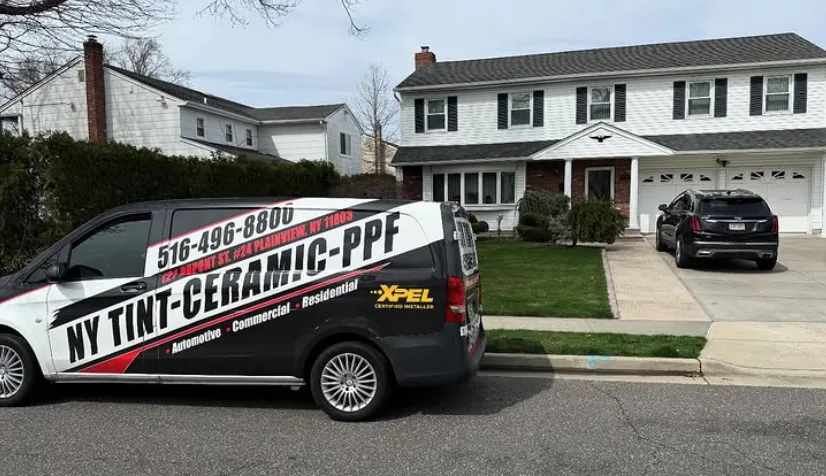 NY Window Tinting van in front of a colonial home with 15% dual reflective privacy film on the front windows