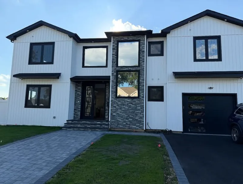 Modern white two-story home with mirror privacy film on the front-facing windows