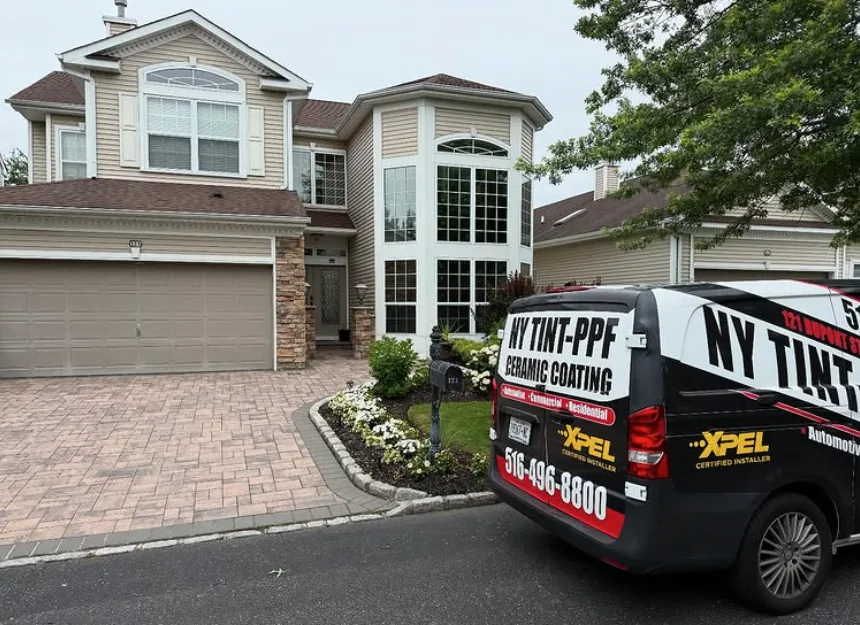NY Window Tinting van parked in the driveway of a Long Island home during a residential window film install