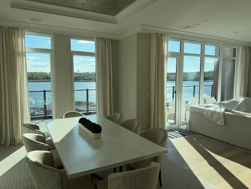Dining room with tinted floor-to-ceiling windows overlooking the water