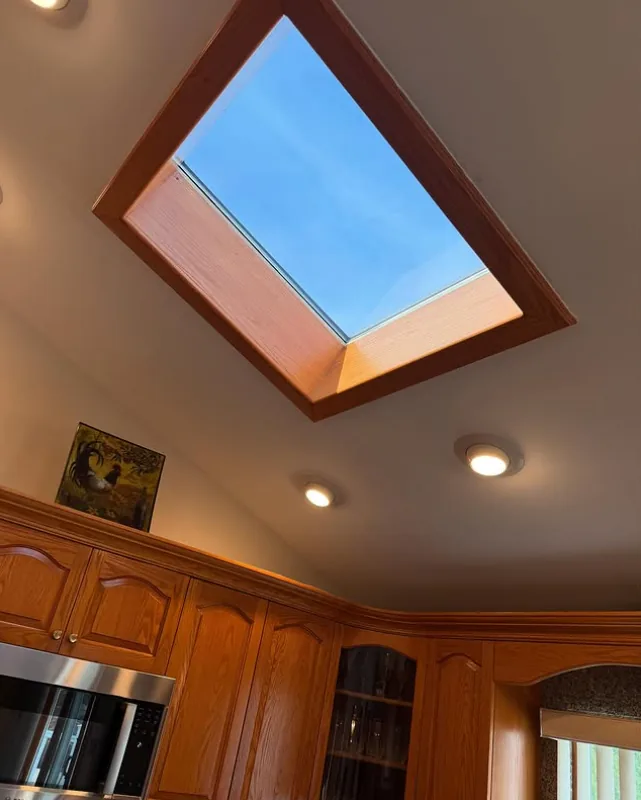 Kitchen skylight with solar film installed, wood cabinets below