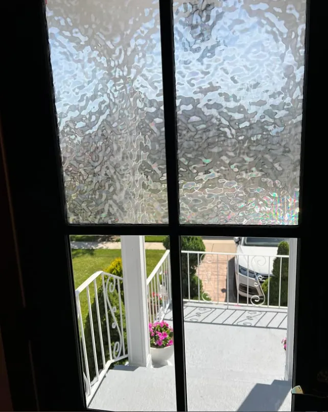 Close-up of wavy textured decorative film on entry door glass, with the porch visible through clear glass below